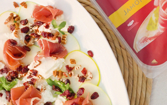 Carpaccio de Pera y Jamón Serrano sobre un plato blanco.